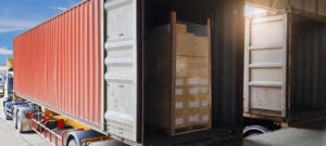 Industry road freight logistics and transportation. Trailer container truck parked loading at dock warehouse. Package boxes load with cargo container.
