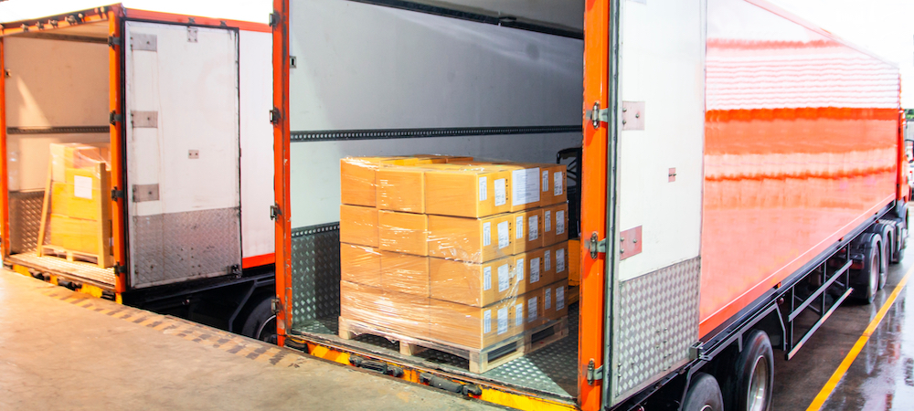 Cargo freight truck. Shipment, Delivery service. Logistics and transportation. Warehouse dock load pallet goods into shipping container truck. Stacked package boxes on pallet inside a truck.
