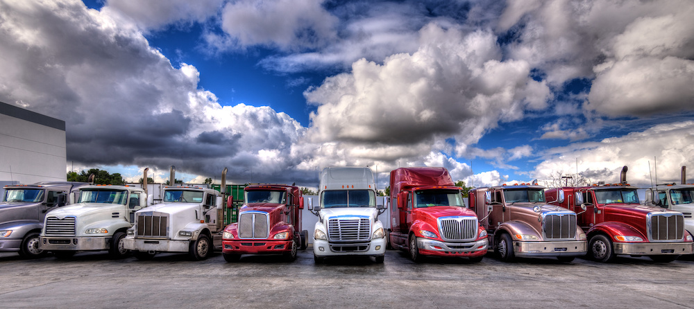 fleet of semi trucks under blue sky