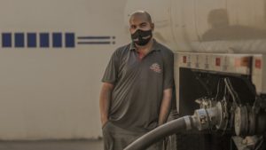 masked man at gas pump