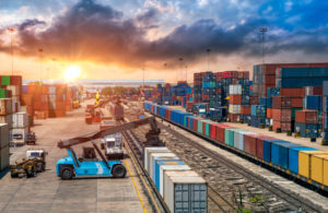 A crowded freight rail yard with train cars getting prepared for transport